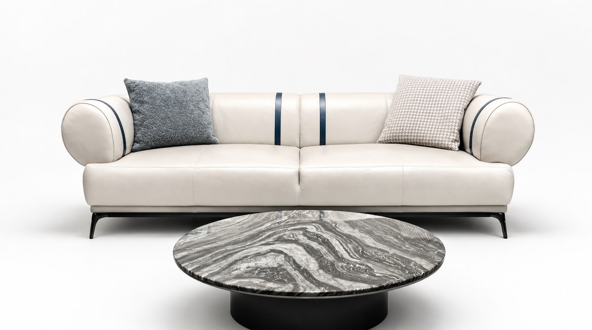 Ivory sofa with striped cylindrical ends; round veined table