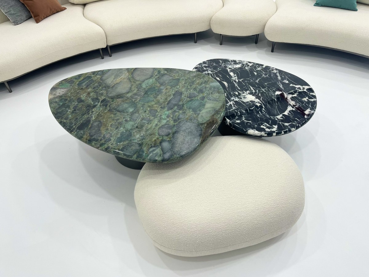 Green irregular table and smaller veined round table; upholstered foreground piece